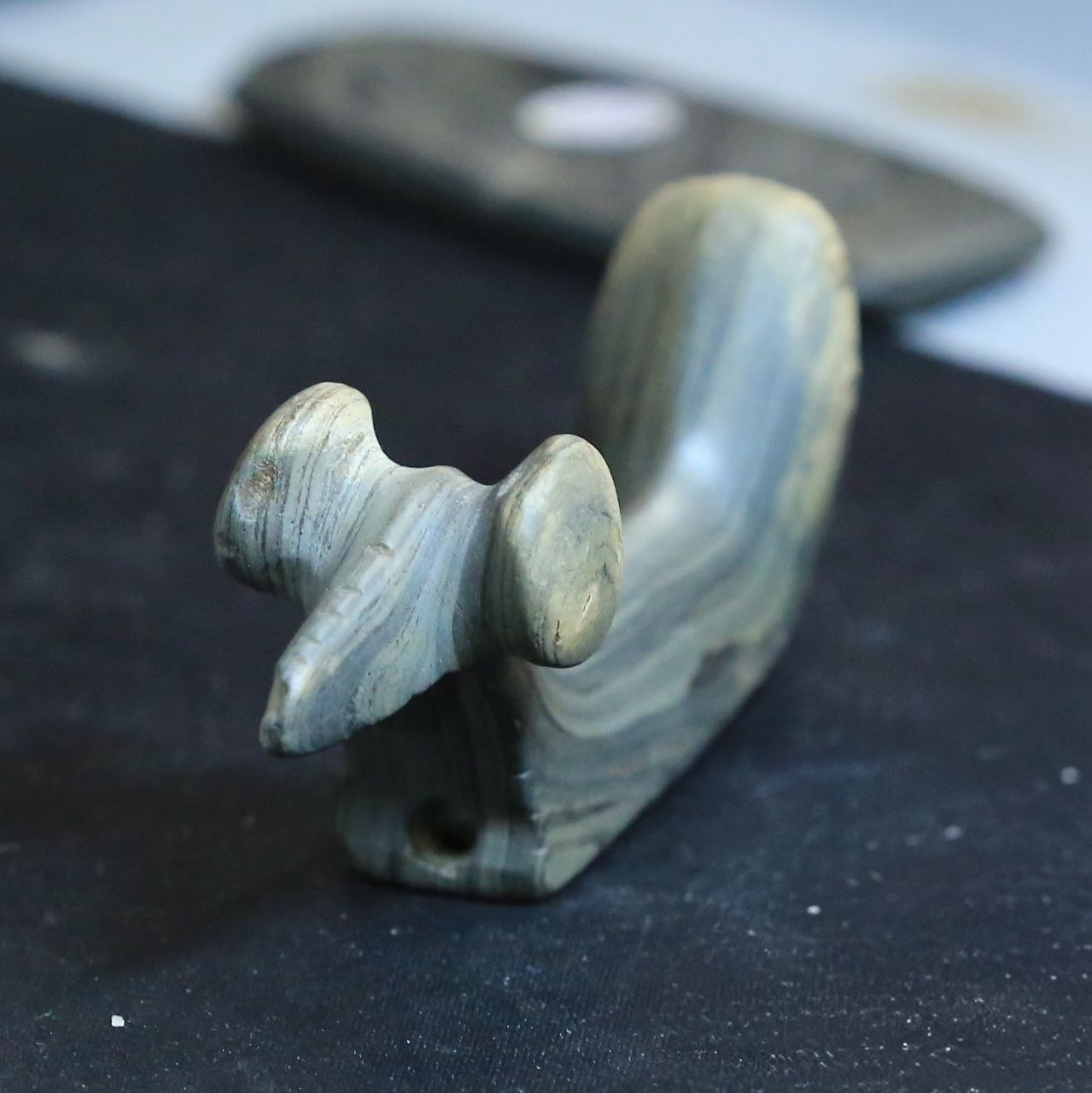 Fine detail — banded slate effigy pipe carving