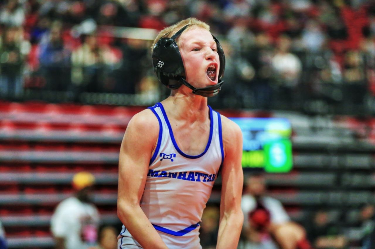 Manhattan wrestler in white singlet roaring during match